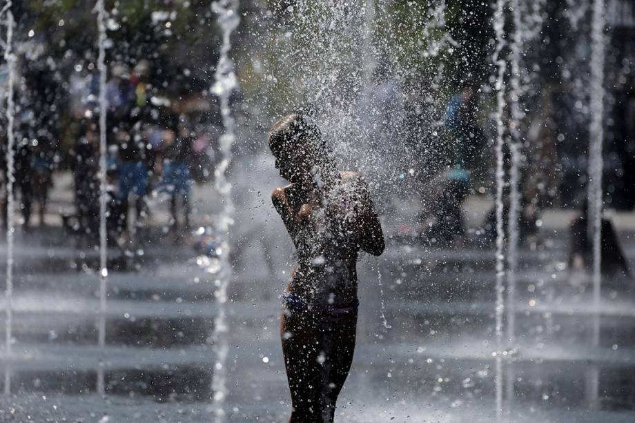 Menina toma banho de chafariz em uma praça na cidade de Nice, na França - 12/07/2017