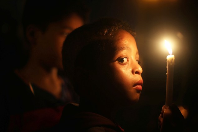 Um garoto palestino segura uma vela durante um protesto contra o bloqueio em Gaza, em Khan Younis - 14/07/2017