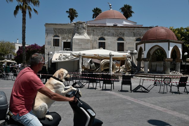 Um homem com seu cachorro passa por uma mesquita destruída em uma praça da ilha grega de Kos, após um terremoto de 6,7 graus que atingiu a Grécia e a estância turca de Bodrum, matando duas pessoas e deixando dúzias de feridos - 21/07/2017