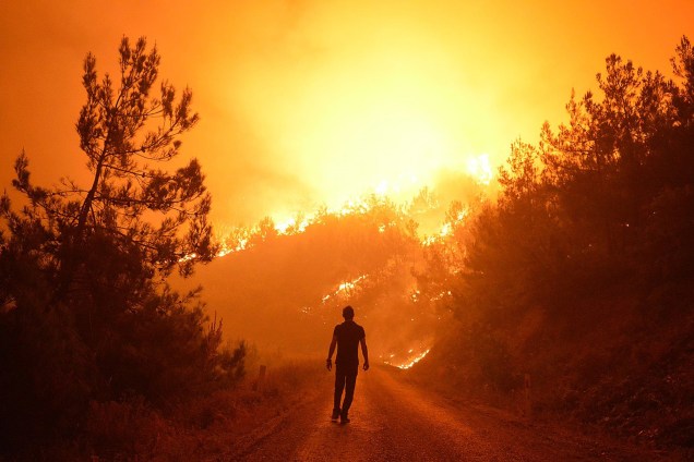 Homem é fotografado em meio a um incêndio florestal no distrito de Bayindir, Izmir, na Turquia. Cerca de 100 hectares de floresta já foram afetados pelo fogo - 25/07/2017