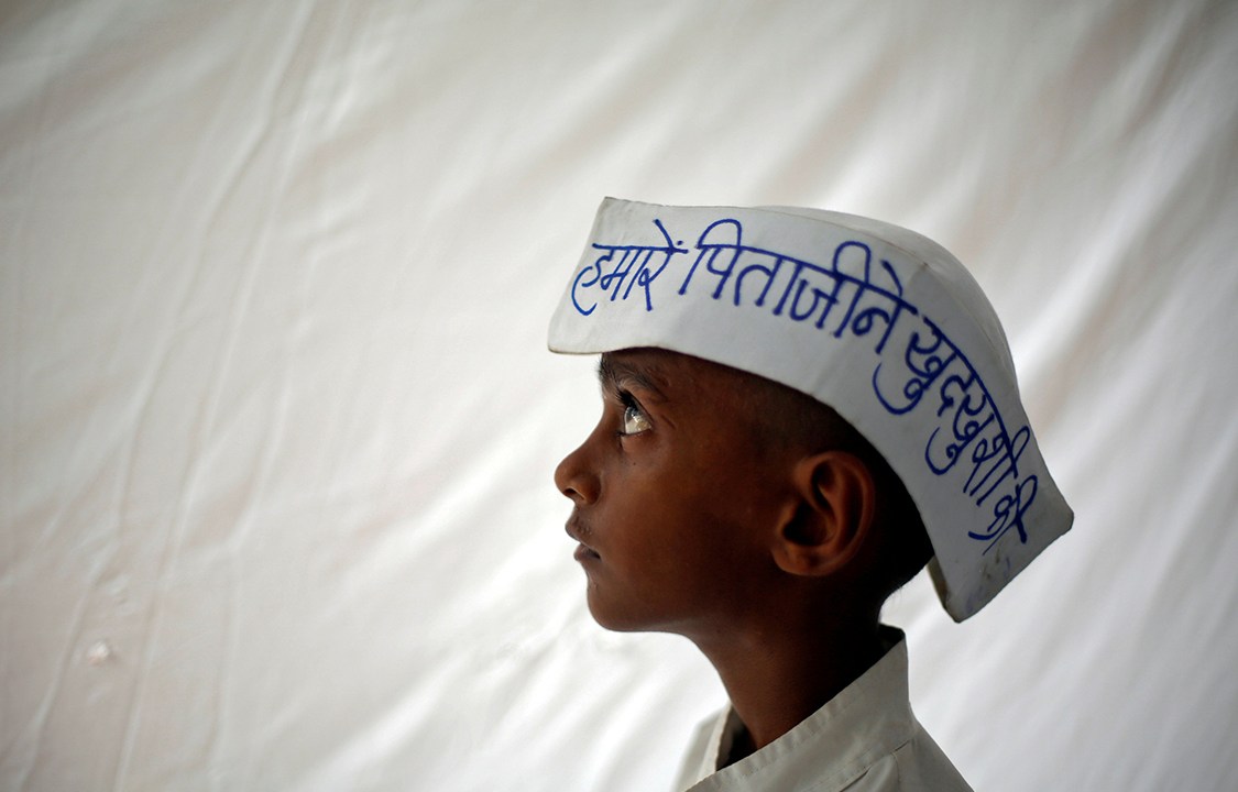 Garoto posa com chapéu em protesto de fazendeiros em Nova Délhi, na Índia, exigindo do governo maior apoio e menos impostos
