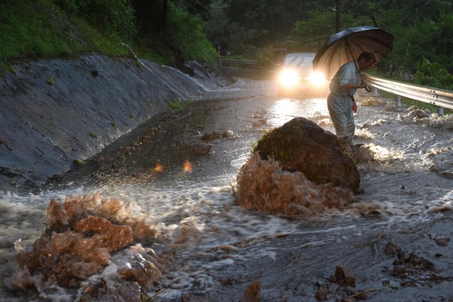 A fotografia da estrada inundada em Hita, na prefeitura de Oita, registra o resultado das fortes chuvas no Japão, rochas foram parar no meio da pista dificultando ainda mais o escoamento da água - 05/07/2017