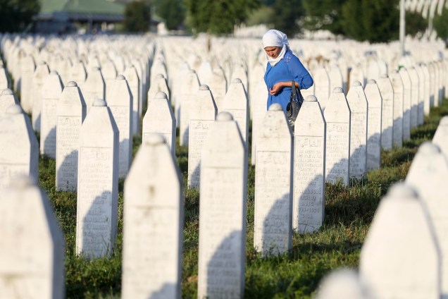 Mulher caminha entre túmulos no memorial dedicado às vítimas do massacre de Srebrenica, na Bósnia e Herzegovina - 11/07/2017