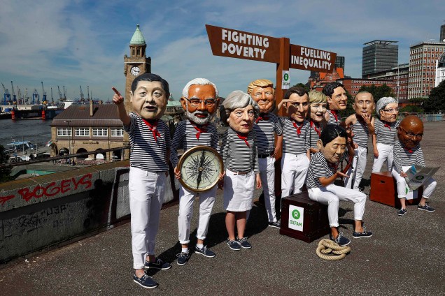 Ativistas da Oxfam usam máscaras representando os principais líderes mundiais durante uma manifestação no porto de Hamburgo durante reunião de cúpula do G20 - 06/07/2017
