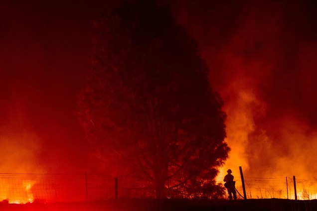 Um bombeiro trabalha para conter as chamas do incêndio Detwiler que se espalha para as proximidades da pequena cidade de Mariposa, na Califórnia
