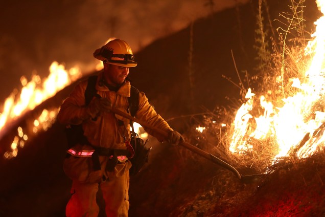 Um bombeiro do condado de Los Angeles trabalha para conter as chamas do incêndio Detwiler que atingiu a pequena cidade de Mariposa, no estado da Califórnia - 18/07/2017