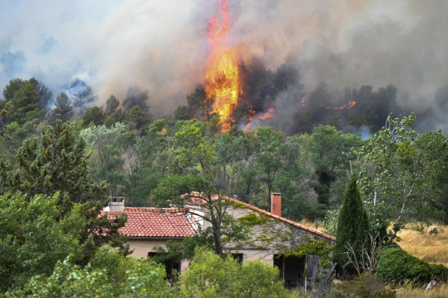 Chamas do incêndio florestal se aproxima de uma casa, perto de Mirabeau, no sudeste da França
