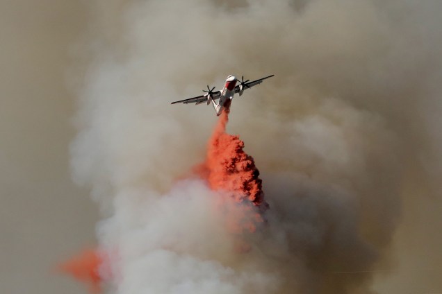 Um avião tenta conter as chamas do incêndio florestal que obrigou cerca de 10 mil pessoas a deixarem suas casa no sudeste da França