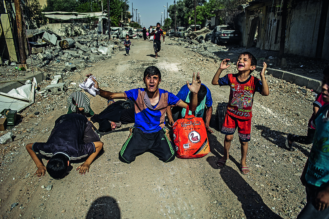 AL&Iacute;VIO &ndash; Ao deixarem a cidade de Mossul, civis ajoelham-se e erguem as m&atilde;os para o c&eacute;u: sinal de que s&atilde;o inocentes