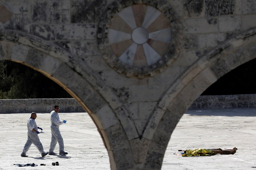 Equipe forense de Jerusalem examina cena do crime em que dois homens armados cometeram homicídio em local sagrado da cidade