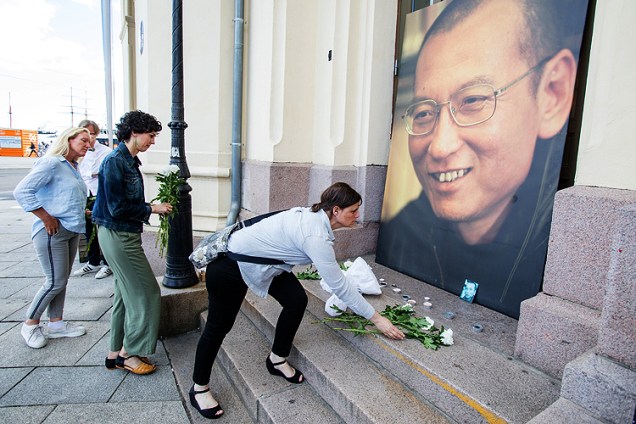 Pessoas deixam flores e velas em frente à foto do dissidente chinês Liu Xiaobo, que morreu aos 61 - 13/07/2017