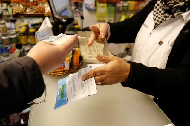 Consumidor adquire pacote de maconha disponível em farmácias na cidade de Montevidéu, Uruguai
