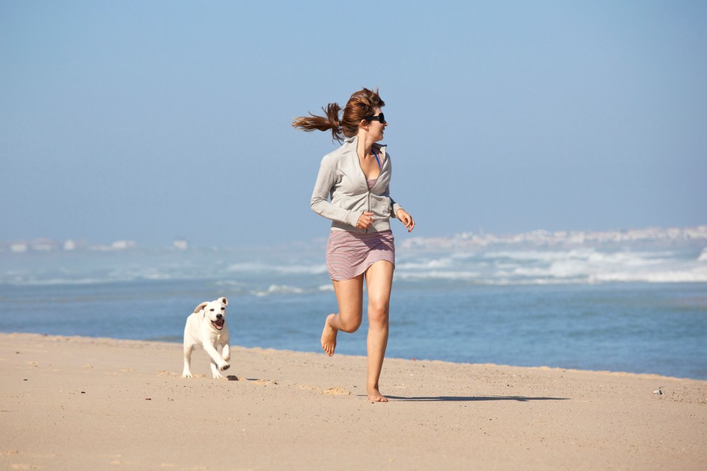 Mulher com cachorro na praia
