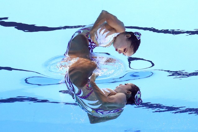 Japonesa é refletida na água em sua apresentação de nado sincronizado solo durante a fase classificatória do Campeonato Mundial de Esportes Aquáticos na Hungria