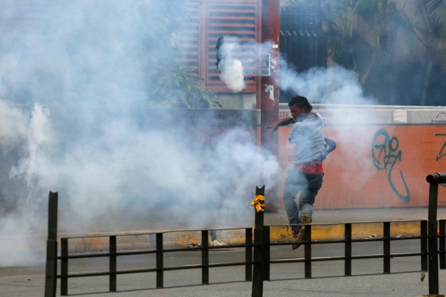 Manifestante lança de volta uma granada de gás lacrimogêneo durante a eleição da Assembleia Constituinte em Caracas, na Venezuela - 30/07/2017