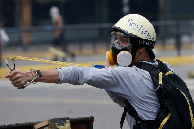 Manifestante usa um estilingue durante confronto com a polícia em Caracas, na Venezuela - 30/07/2017