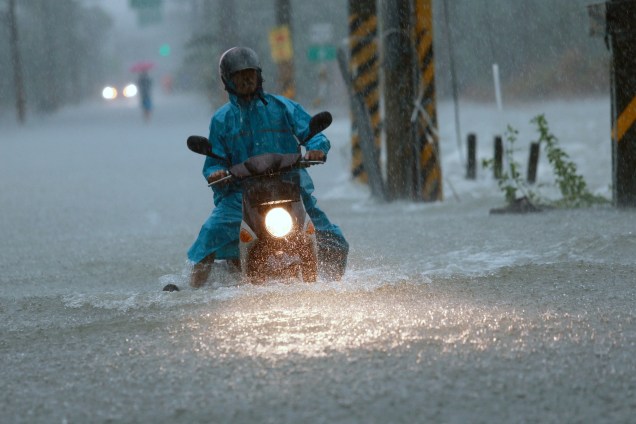 Motociclista atravessa uma rua inundada após a passagem do tufão Nesat em Pingtung, no sul de Taiwan - 29/07/2017
