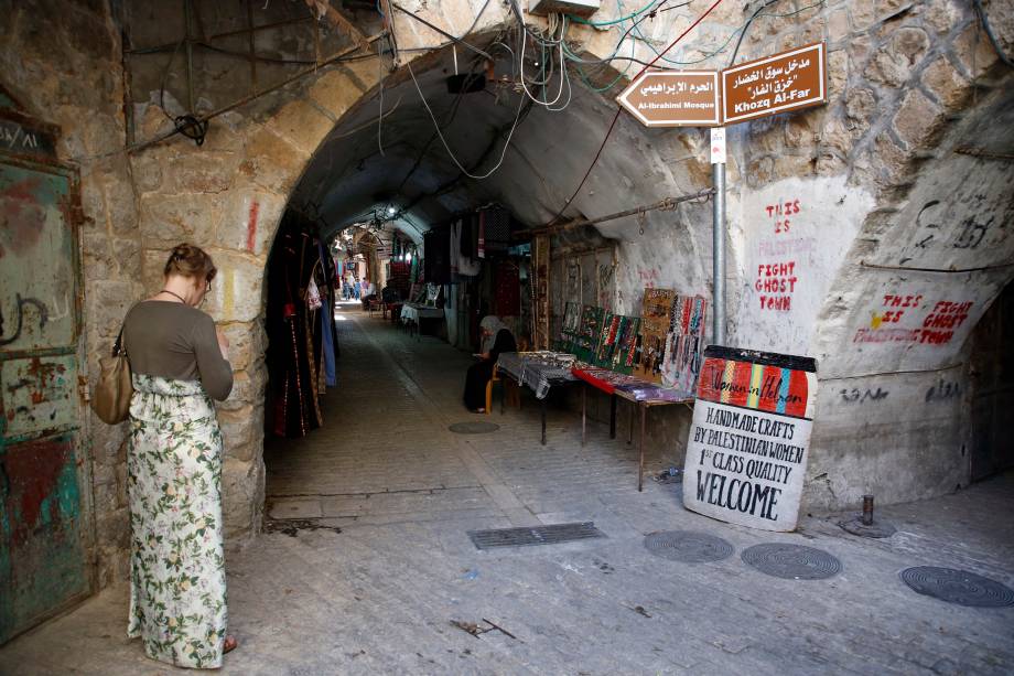 Mulher caminha no antigo mercado da cidade de Hebron, na Cisjordânia