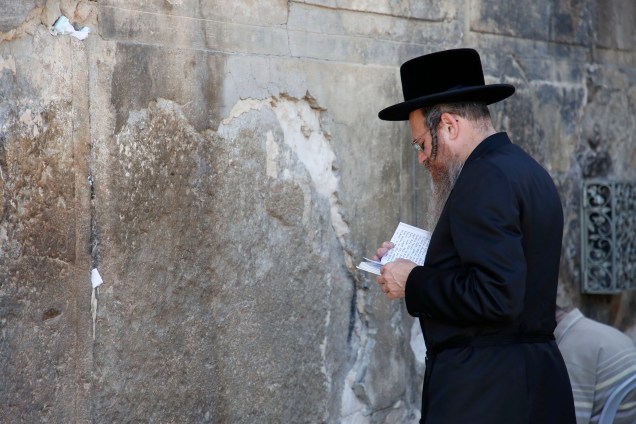 Judeu ultra-ortodoxo faz orações do lado de fora do túmulo dos Patriarcas ou da Mesquita de Ibrahimi, local sagrado para judeus e muçulmanos, na cidade de Hebron, na Cisjordânia