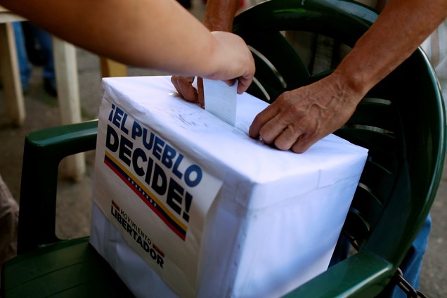 Pessoas depositam voto em urna durante plebiscito que vota contra o presidente Nicolas Maduro, em Caracas, na Venezuela - 16/07/2017