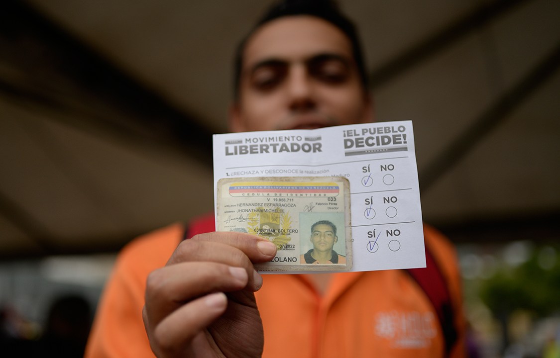 Eleitor exibe seu voto antes de depositá-lo em urna, durante plebiscito não-oficial organizado contra o presidente Nicolás Maduro
