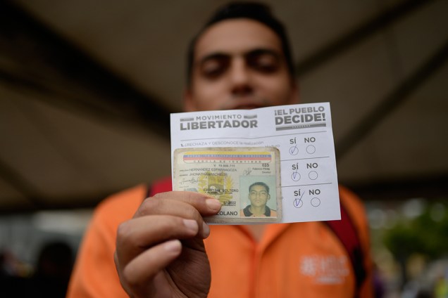 Eleitor exibe seu voto antes de depositá-lo em urna, durante plebiscito não-oficial organizado contra o presidente Nicolás Maduro - 16/07/2017