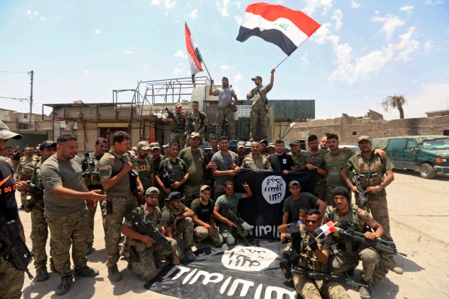 Membros da Divisão Especial de Emergência iraquiana comemoram na Cidade Velha de Mossul, Iraque