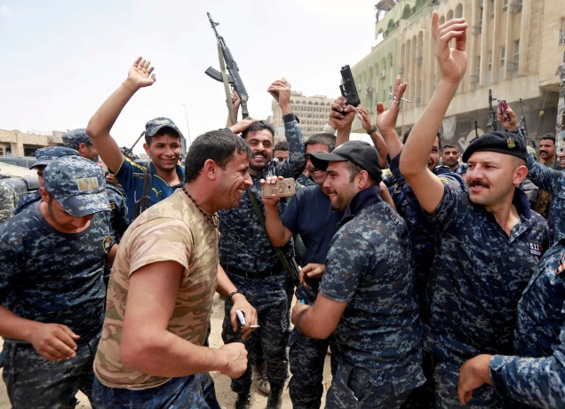 Membros da Polícia Federal iraquiana comemoram na Cidade Velha de Mossul, Iraque