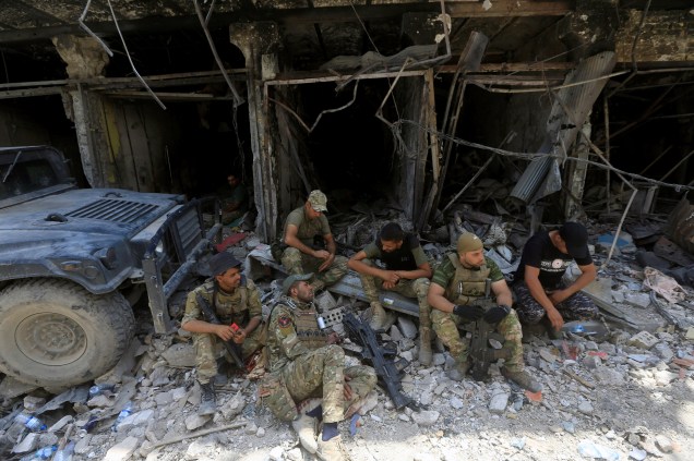 Membros da Divisão Especial de Emergência iraquiana descansam na Cidade Velha de Mossul, Iraque
