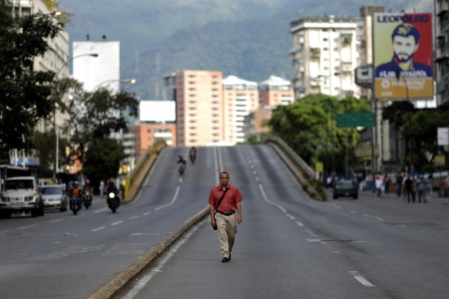 Homem anda em uma rua vazia durante o primeiro dia da greve geral convocada pela oposição ao presidente venezuelano Nicolás Maduro, em Caracas - 26/07/2017