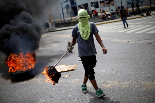 Manifestante da oposição venezuelana bloqueia uma rua durante a greve geral de 48 horas contra o presidente Nicolás Maduro, em Caracas - 27/07/2017