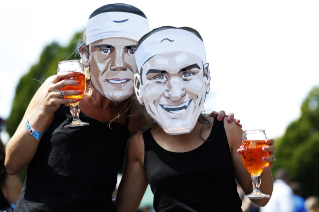Torcedoras usam máscaras dos tenistas Roger Federer e Rafael Nadal, em Wimbledon