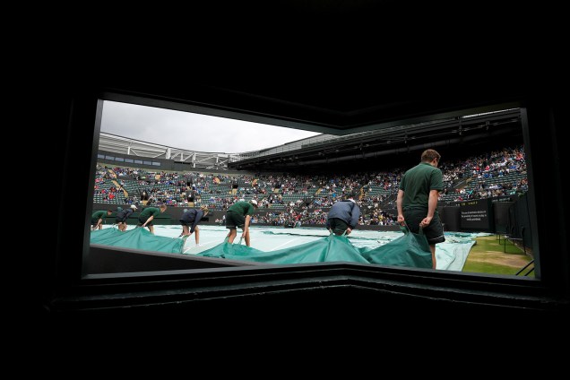 Assistentes cobrem quadra devido à chuva, em Wimbledon