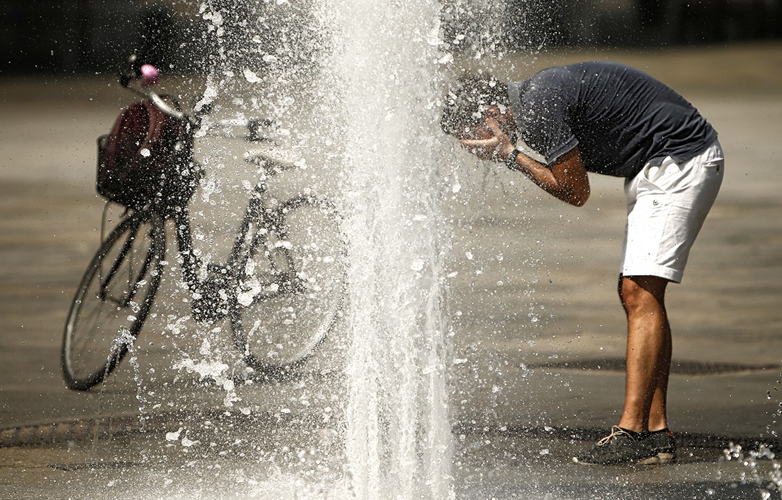 Ciclista se refresca em chafariz durante onda de calor na Itália e também em outros países da Europa, apelidada de Lúcifer