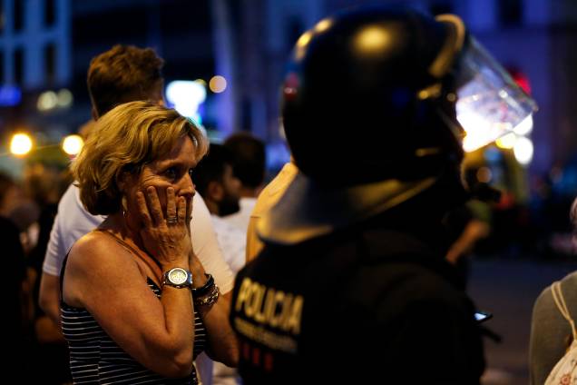 Mulher reage ao atentado após ser retirada da área onde foram atropelados cidadãos e turistas resultando na morte de 14 pessoas e deixando dezenas de feridos, em Barcelona, na Espanha
