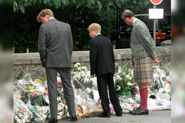 Príncipe William, príncipe Harry e seu pai, o príncipe Charles, caminham do lado de fora dos portões do Castelo de Balmoral para observar os tributos prestados à princesa Diana - 04/09/1997