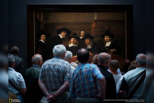 Durante uma ida ao Rijksmuseum, em Amsterdam, o fotógrafo Julius Y. parou em frente a obra-prima da Rembrandt, Syndics of the Drapers 'Guild, e registrou como os homens do quadro parecem olhar curiosamente para os expectadores Durante uma ida ao Rijksmuseum, em Amsterdam, o fotógrafo Julius Y. parou em frente a obra-prima da Rembrandt, Syndics of the Drapers 'Guild, e registrou como os homens do quadro parecem olhar curiosamente para os expectadores