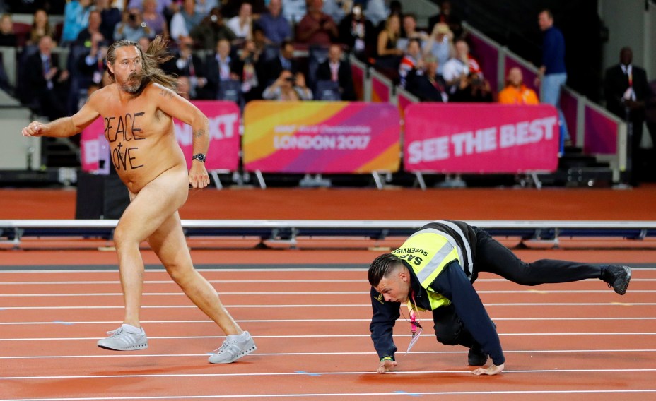 Seguranças tentam conter manifestante que invadiu o estádio nu durante prova do Mundial de Atletismo