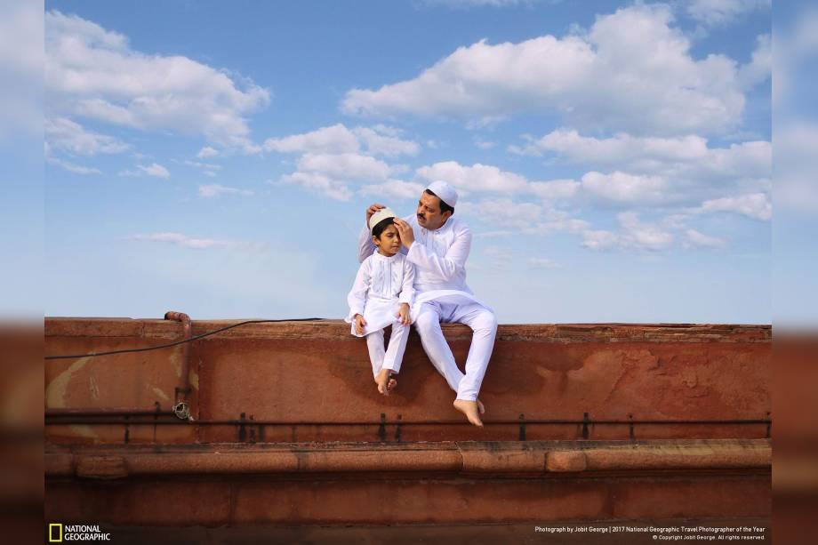 Em Nova Deli, na capital da Índia, pai e filho sentados em uma mesquita arrumam seus trajes tradicionais para o Eid al-Fitr, que marca o fim do jejum do Ramadã