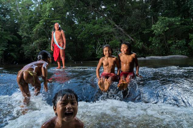 Jurara Wajãpi, um dos chefes dos Waiãpi, acompanha crianças da tribo no Rio Onça, que passa pela aldeia na região de Pedra do Amapari (AP)
