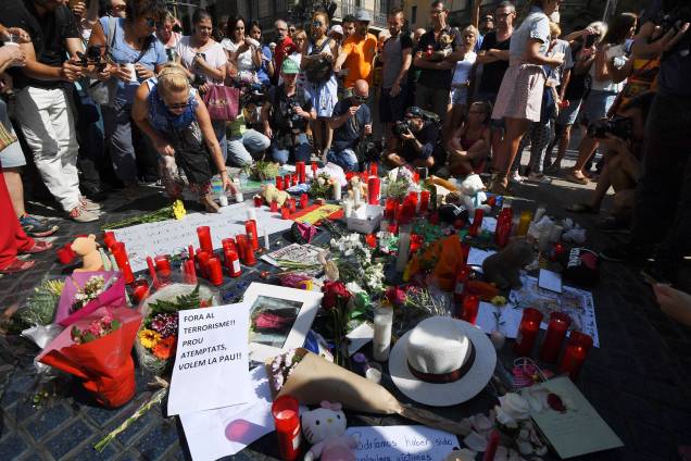 Pessoas levam flores, velas e cartazes para homenagear as vitimas do atropelamento terrorista em La Rambla, Barcelona, na Espanha