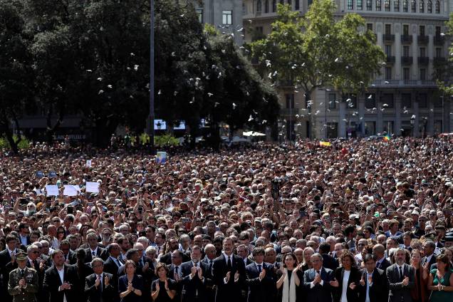 O rei Felipe VI se encontra ao lado de outras figuras políticas como o primeiro-ministro Mariano Rajoy e Carles Puigdemont, presidente da Generalidade da Catalunha, durante homenagem às vitimas do atropelamento terrorista da última quinta-feira
