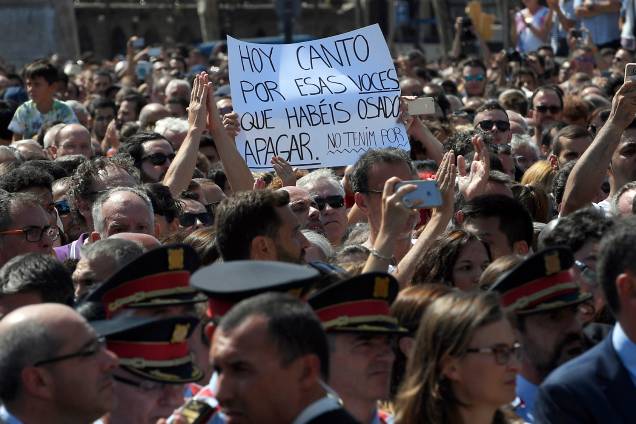 Cartaz com homenagem às vitimas do atentado terrorista em Barcelona é fotografado durante solenidade