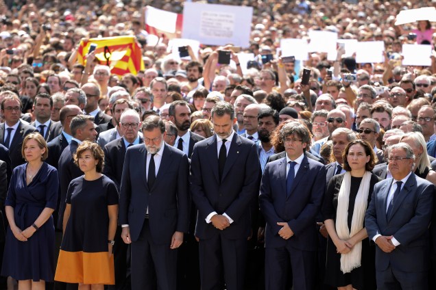 O rei Felipe VI se encontra ao lado de outras figuras políticas como o primeiro-ministro Mariano Rajoy e Carles Puigdemont, presidente da Generalidade da Catalunha, durante o minuto de silêncio em solenindade às vitimas do atropelamento terrorista da última quinta-feira