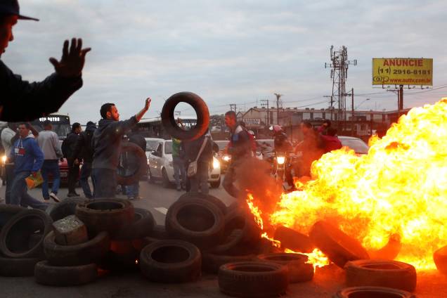 Integrantes do Movimento dos Trabalhadores dos Sem-Teto (MTST) usam pneus para construir uma barricada na BR116 em protesto contra Michel Temer, São Paulo - 02/08/2017