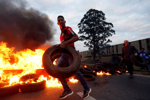 Manifestantes do Movimento dos Trabalhadores dos Sem-Teto (MTST) ateiam fogo em pneus para bloquear rodovia durante protesto contra Michel Temer em São Paulo - 02/08/2017