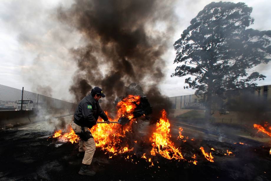 Policial Federal tenta desmanchar barricada feita pelos manifestantes do MTST durante protesto contra o presidente Temer na rodovia BR116, em São Paulo - 02/08/2017