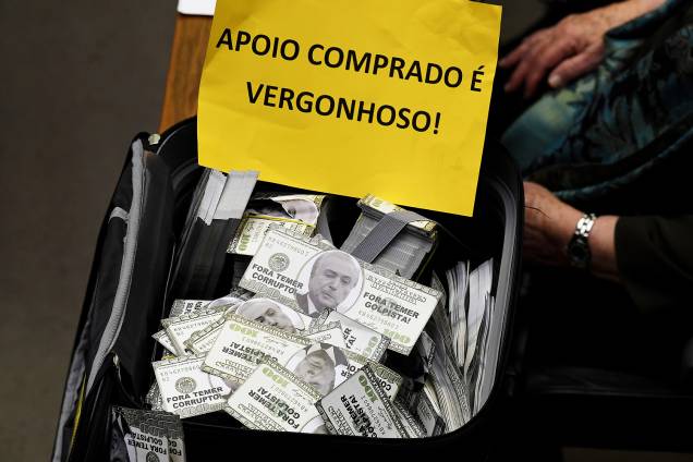 Oposição carrega mala com dinheiro falso e placas contra Temer durante o protesto na discussão da Câmara dos Deputados sobre a denúncia de corrupção passiva do Presidente - 02/08/2017 Oposição carrega mala com dinheiro falso e placas contra Temer durante o protesto na discussão da Câmara dos Deputados sobre a denúncia de corrupção passiva do Presidente - 02/08/2017