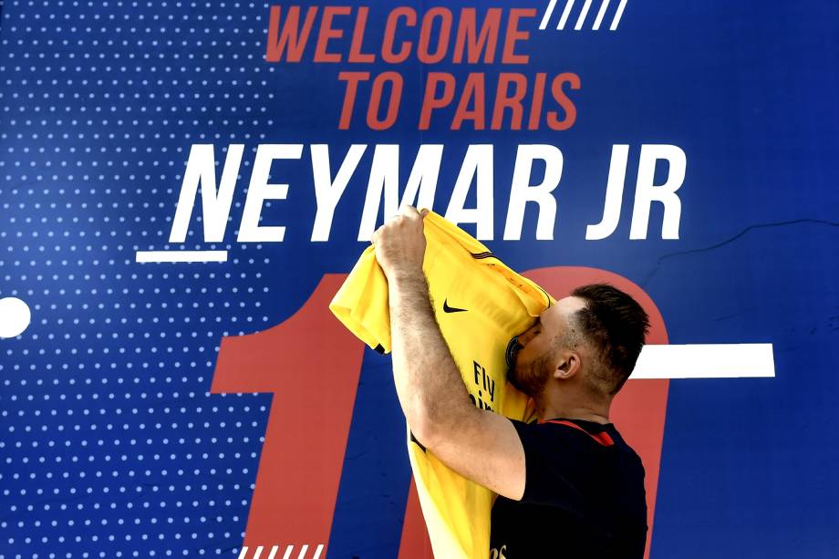 Torcedor beija a camisa recém adquirida de Neymar em frente à loja oficial do PSG em Paris