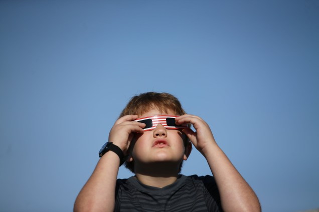 Menino usa óculos especial para acompanhar o eclipse solar em Depoe Bay, no estado americano do Oregon - 21/08/2017